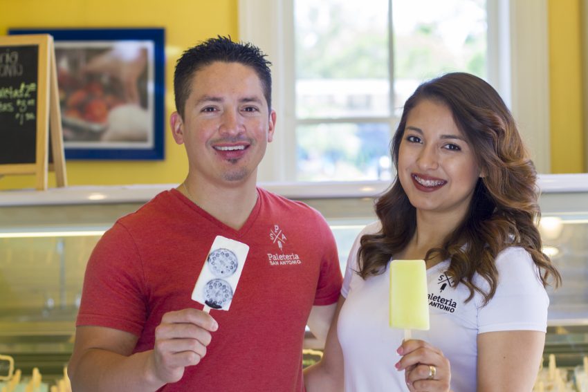 Male and Female owners of Paleteria stand holding paletas.