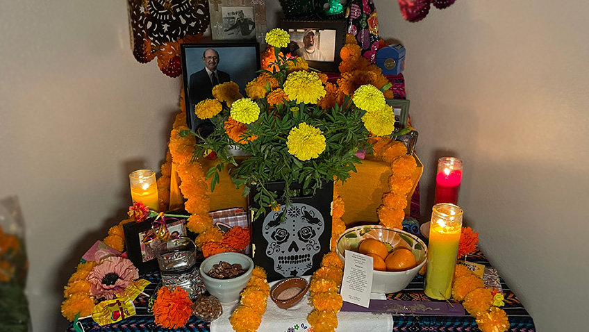 Melanie's Ofrenda for Dia de Muertos 2023 - papel picado, picture frames, marigolds, candles, food and colorful layers