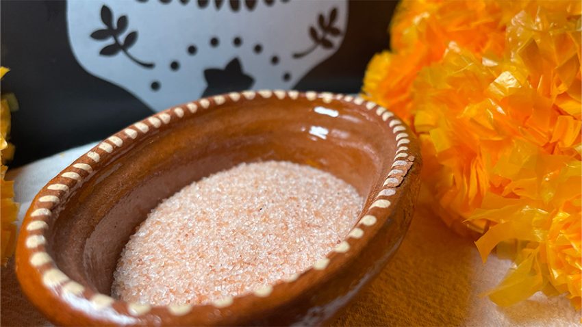 small bowl of pink salt for dia de muertos ofrenda